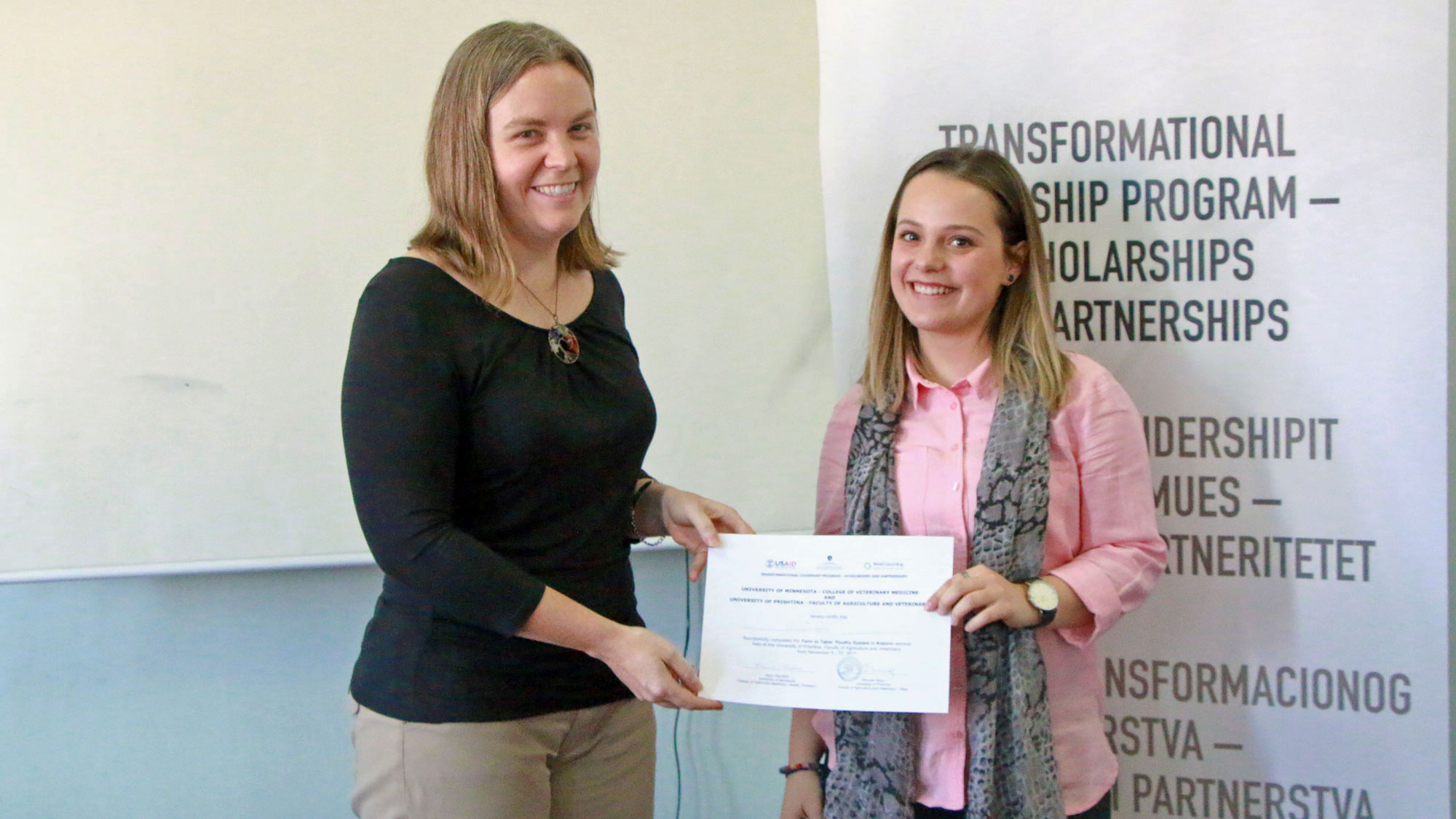 Karin Hamilton handing a certificate of completion to a veterinary student at the University of Prishtina, Kosovo