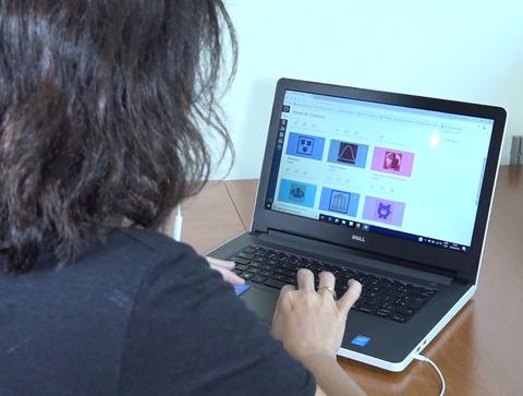 A woman navigates Canvas courses on her laptop