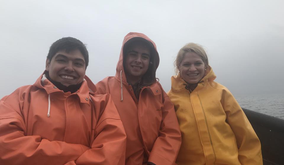 Amy Kinsley on a salmon boat with two other Chilean researchers
