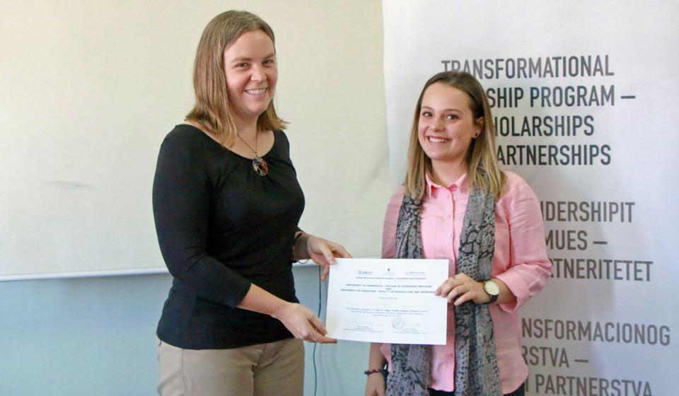 Karin Hamilton handing a certificate of completion to a veterinary student at the University of Prishtina, Kosovo