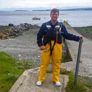 Dr. Gil Patterson standing in front of salmon farms
