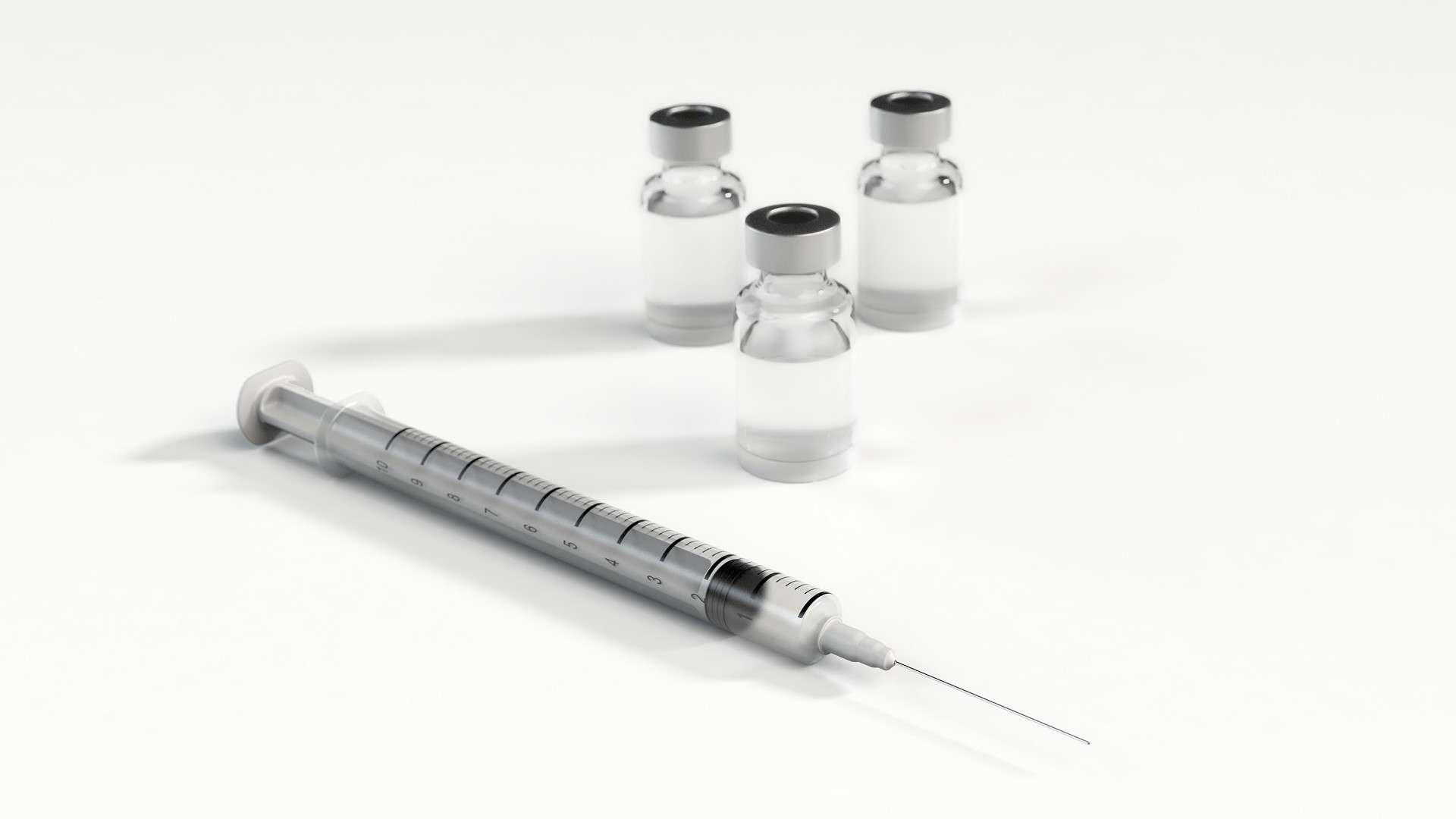 Photo of a syringe and a vial of liquid vaccine